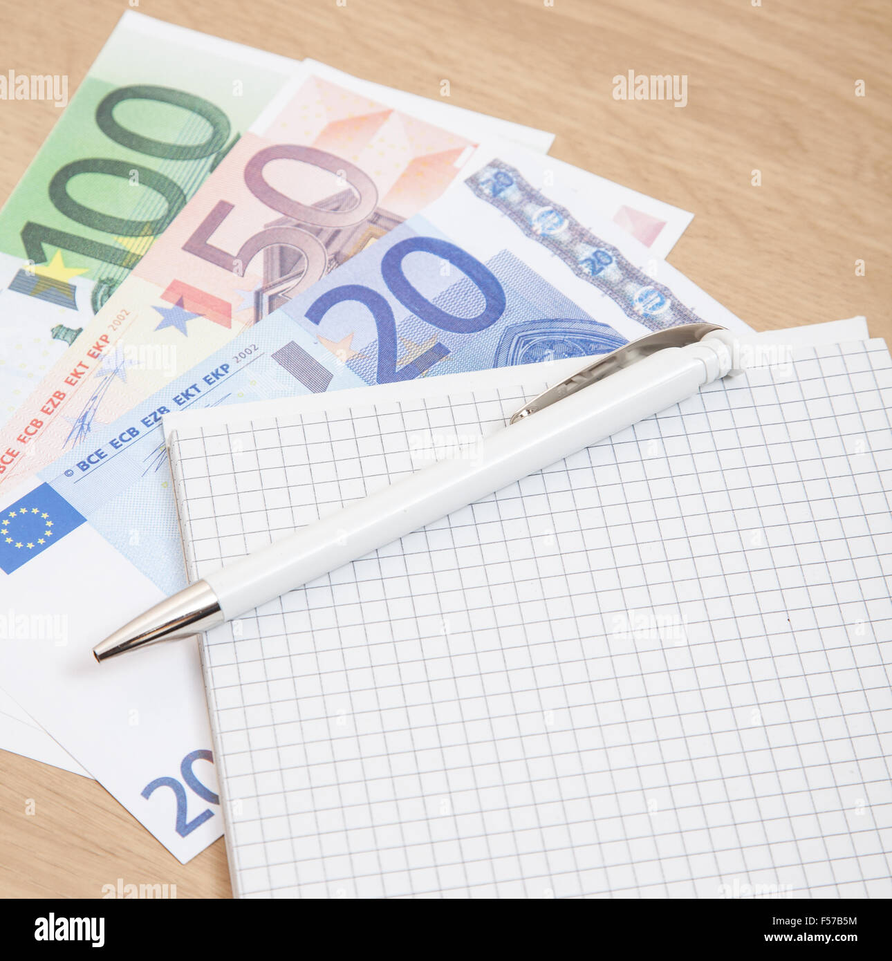 Various euro notes next to notepad on desk Stock Photo