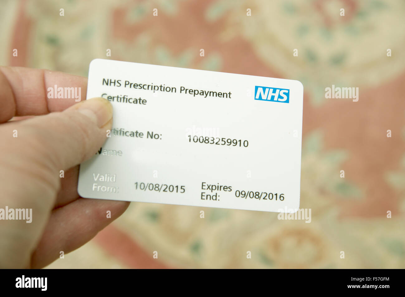 Woman holding an NHS prescription prepayment certificate (useful 
