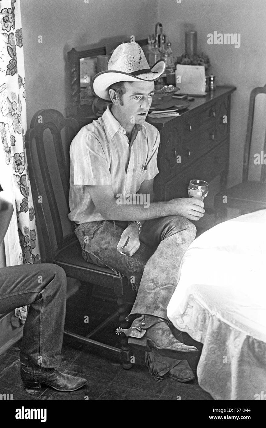 A ranch cowboy named Ray Howe sits in the kitchen of a ranch house in new mexico and drinks a glass of iced tea. Stock Photo