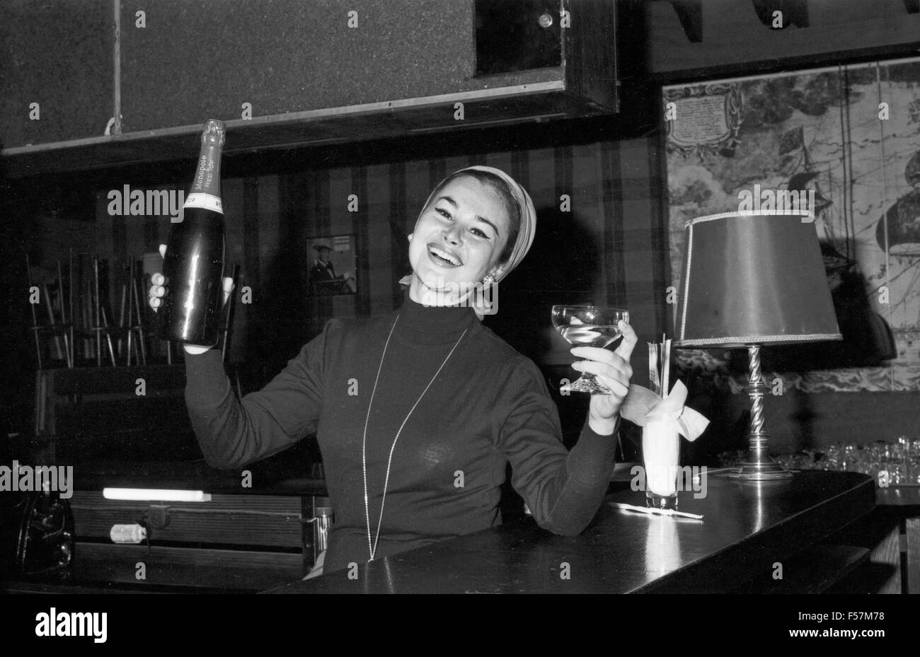 Deutsche Schauspielerin Evi Kent trinkt einen Sekt an der Bar, Deutschland 1960er Jahre. German actress Evi Kent having a glass of sparkling wine, Germany 1960s. 24x36swNeg89 Stock Photo
