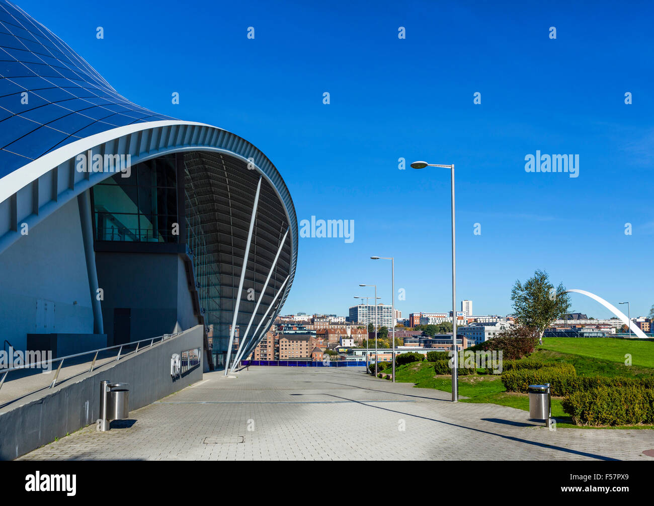 The entrance to the Sage Gateshead with the Millennium Bridge in the distance, Newcastle, Tyne and Wear, UK Stock Photo