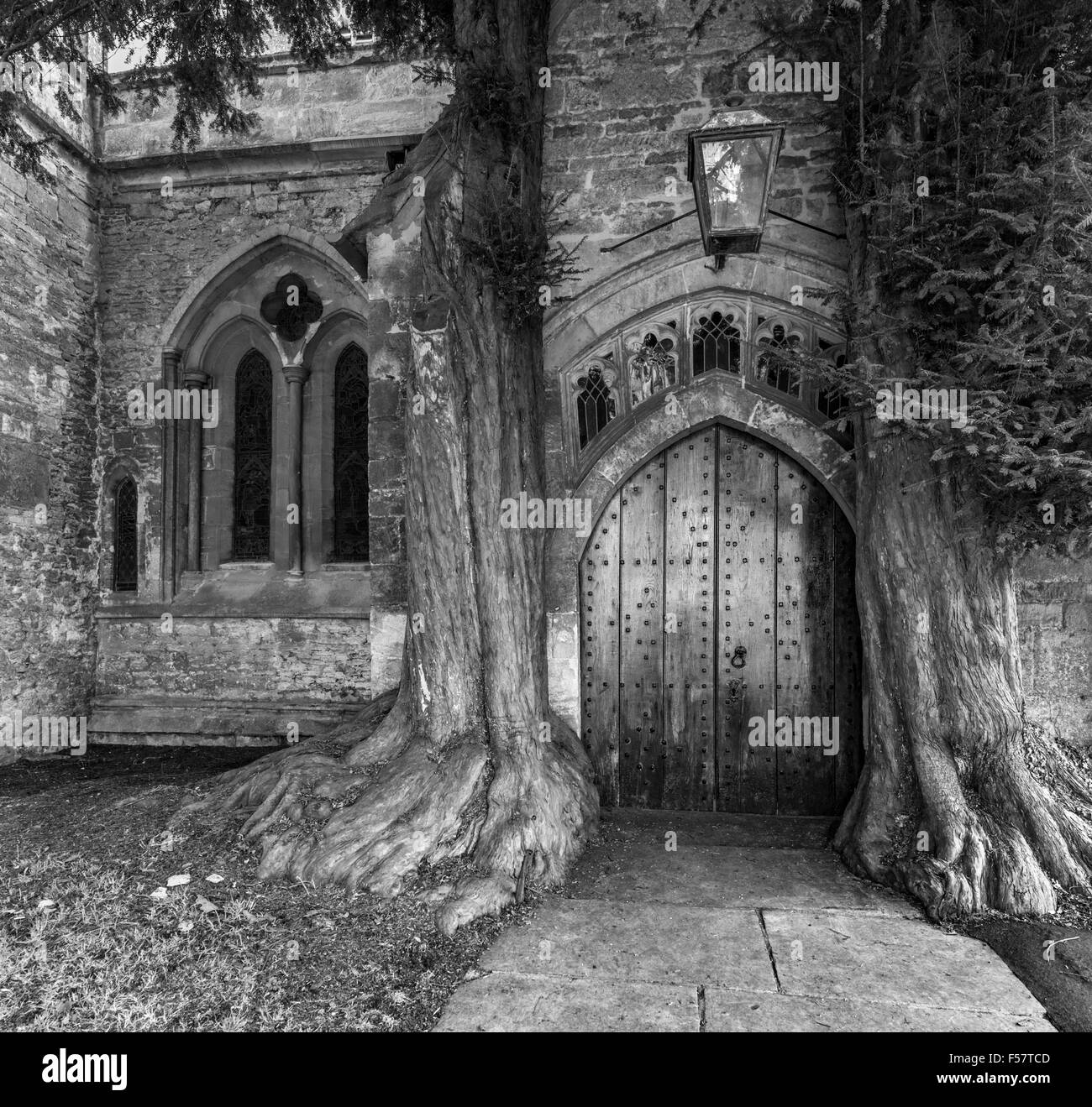 The north door of St Edwards church with two ancient yew trees either side, Stow on the Wold, Gloucestershire, England, UK Stock Photo