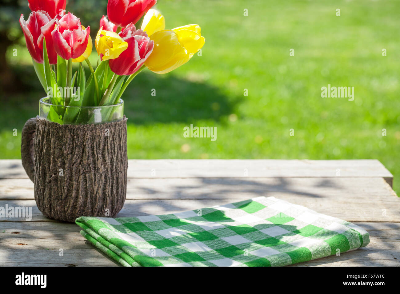 Colorful tulips on garden table with green grass bokeh Stock Photo - Alamy