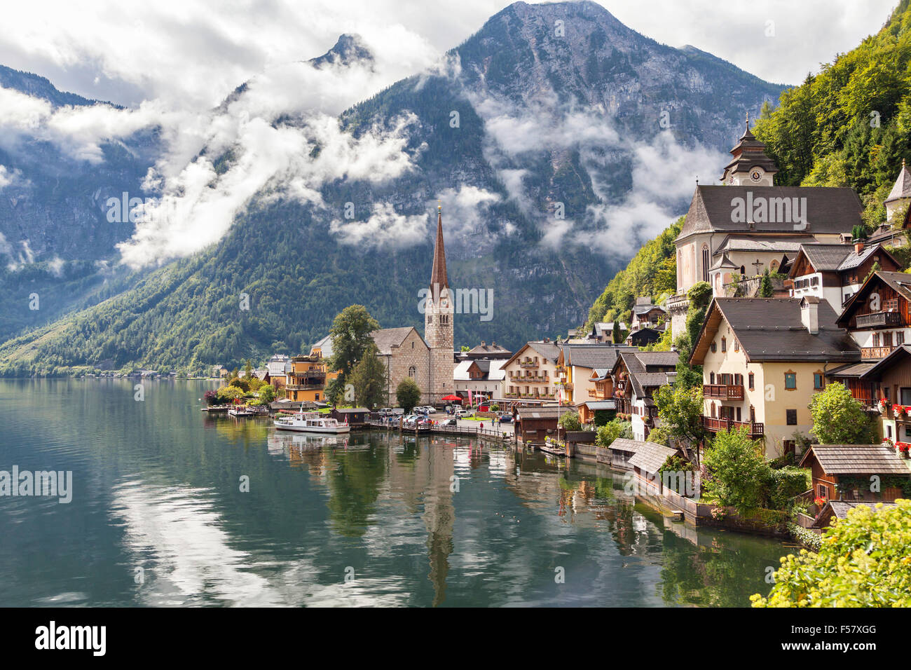 Hallstatt village in Austrian Alps with clouds and mountain lake Stock Photo