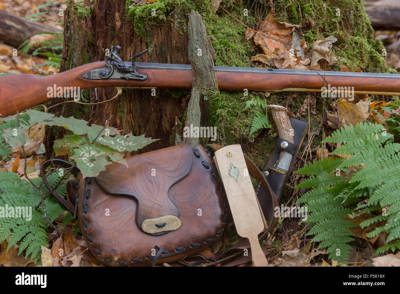 A traditional flintlock rifle and accessories in the autumn woods