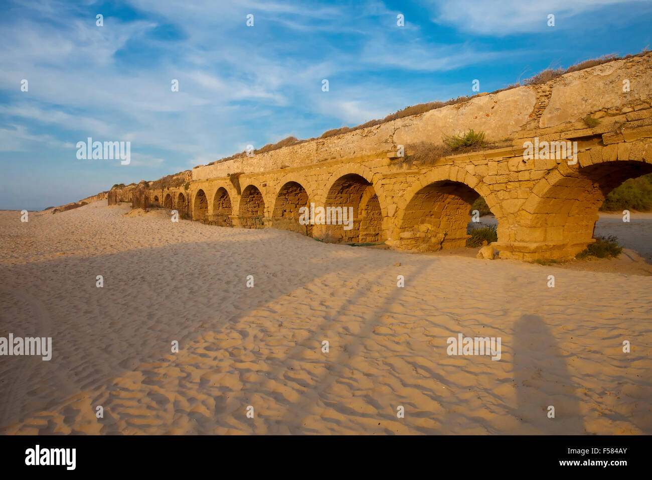 Golden-lit stones of Roman aqueduct in Caesarea at sunset (sunset ...