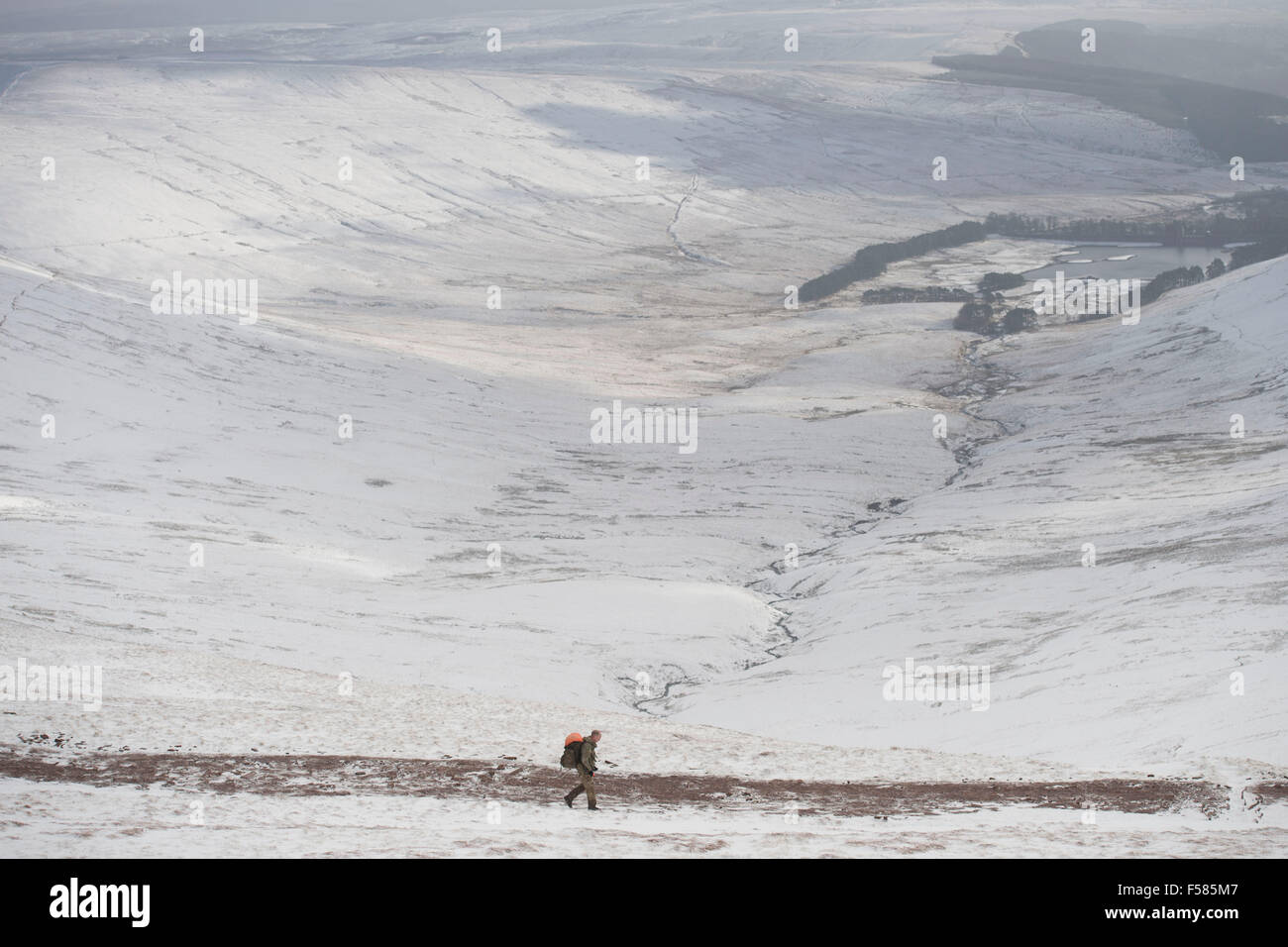 Walkers walk through heavy deep snow at Pen y Fan mountain, Brecon
