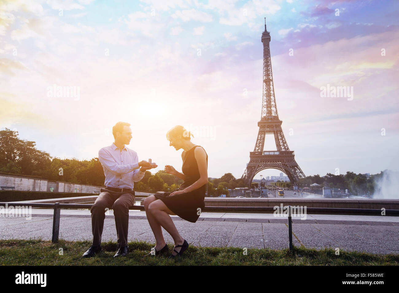 marry me, proposal at Eiffel Tower in Paris, beautiful silhouettes of young caucasian couple Stock Photo