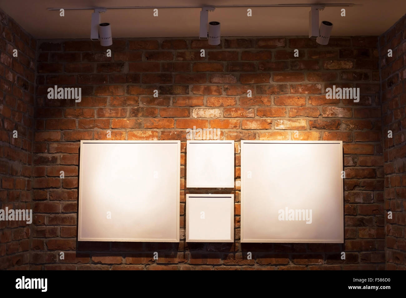 blank white boards in frames on brick wall, abstract interior background with place for text Stock Photo