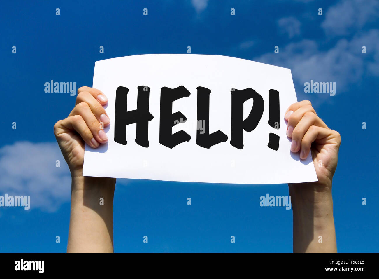 Help sign in hands on blue sky background Stock Photo