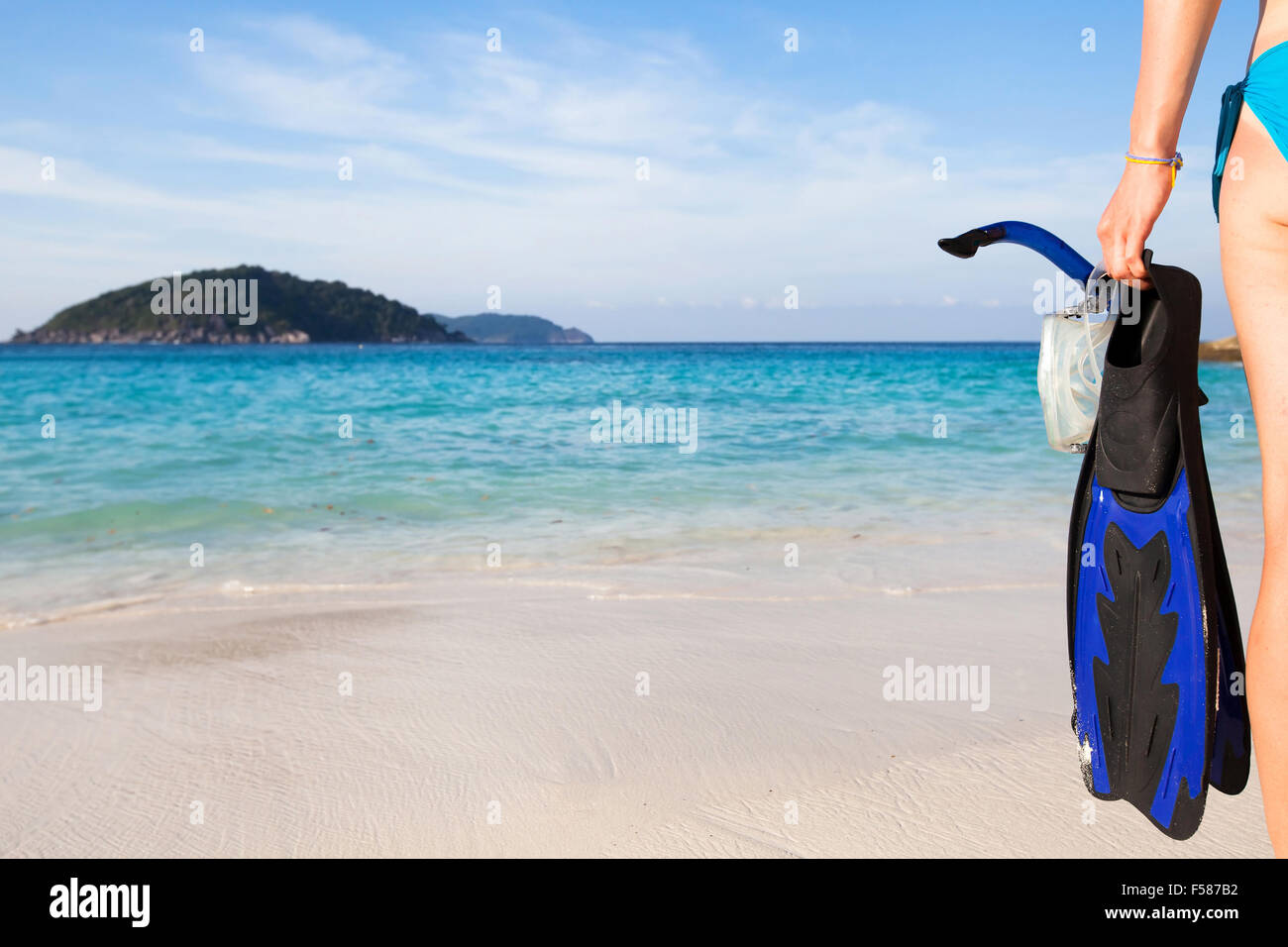 snorkeling on paradise island, background with hand holding fins and mask with snorkel Stock Photo