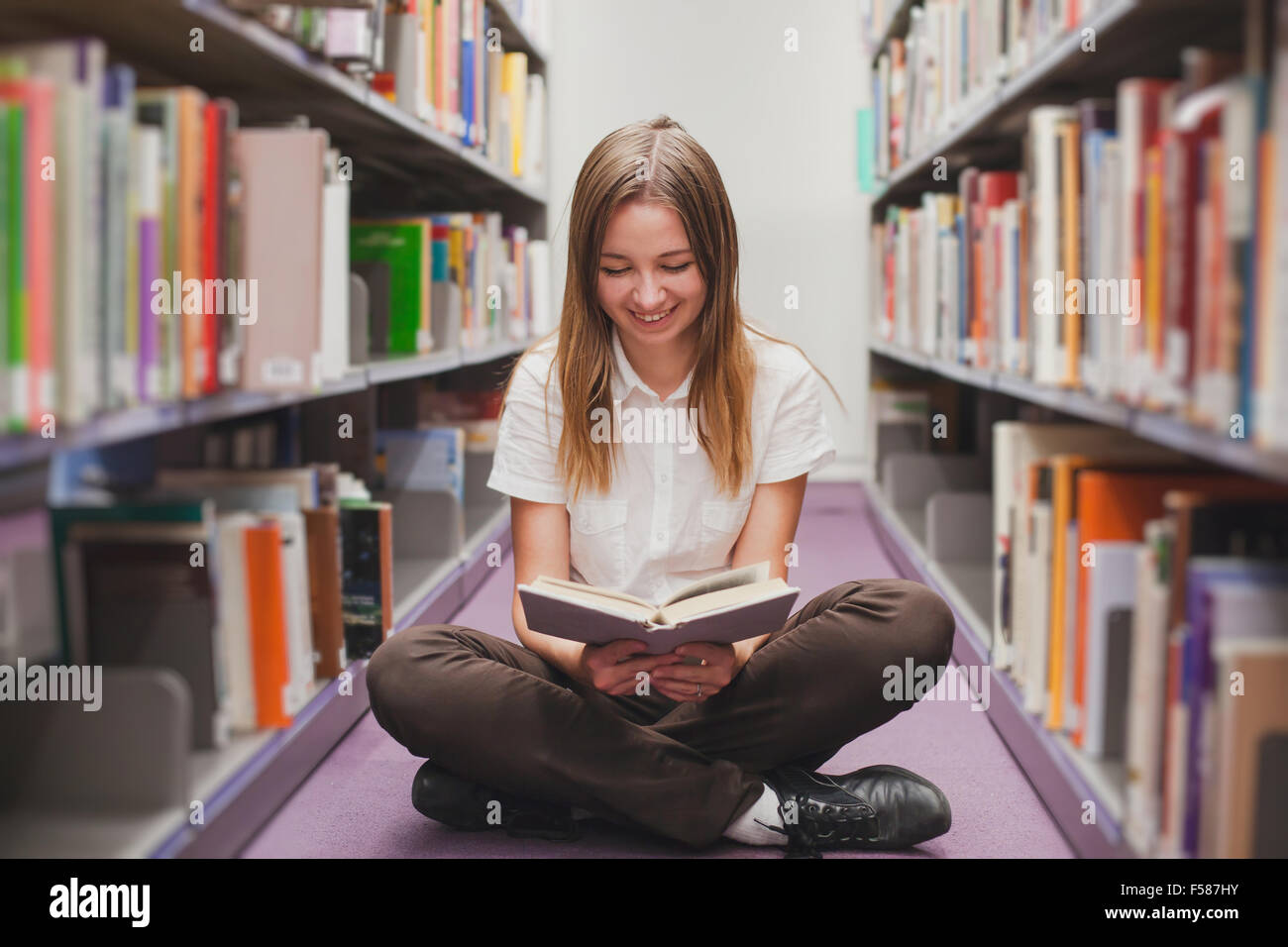 girl reading in the library, smiling happy student Stock Photo