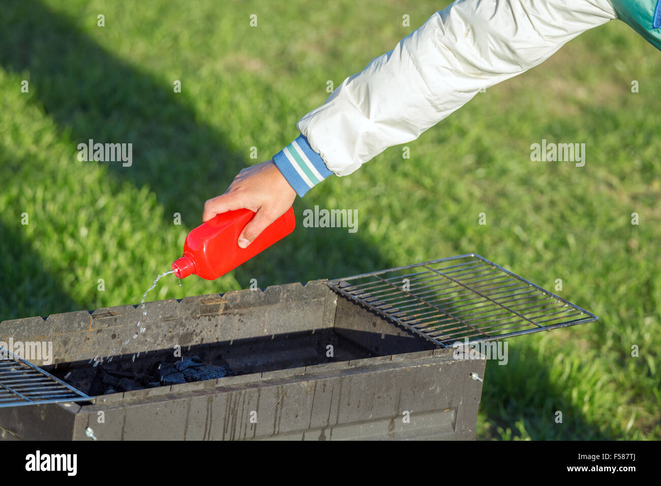 Man Using Liquid Fire to Start Barbecue Stock Photo Alamy