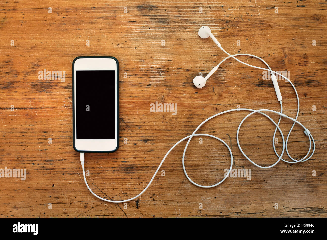 smart phone and earphones on wooden background Stock Photo