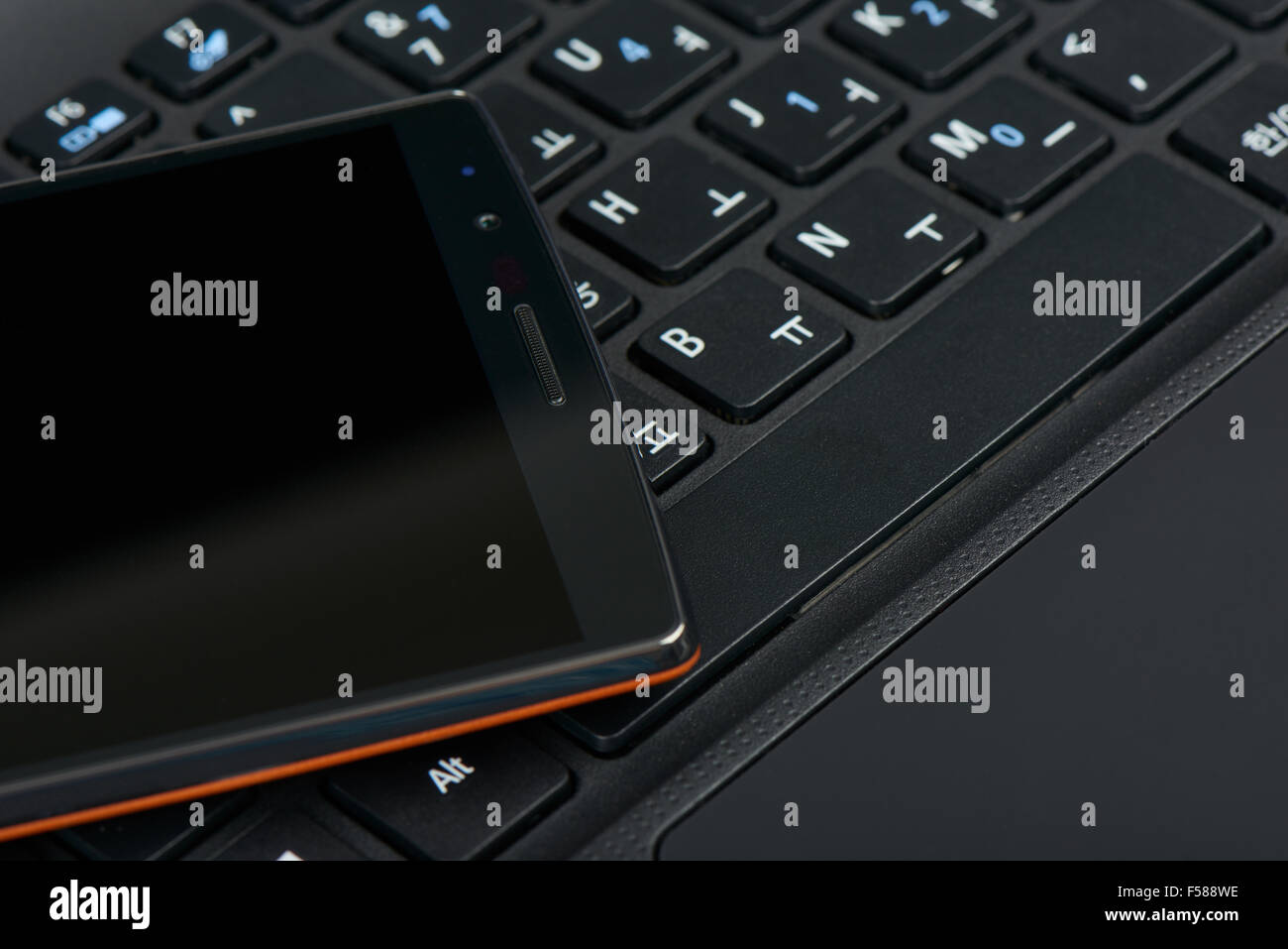 closeup of smartphone on a korean keypad of laptop Stock Photo