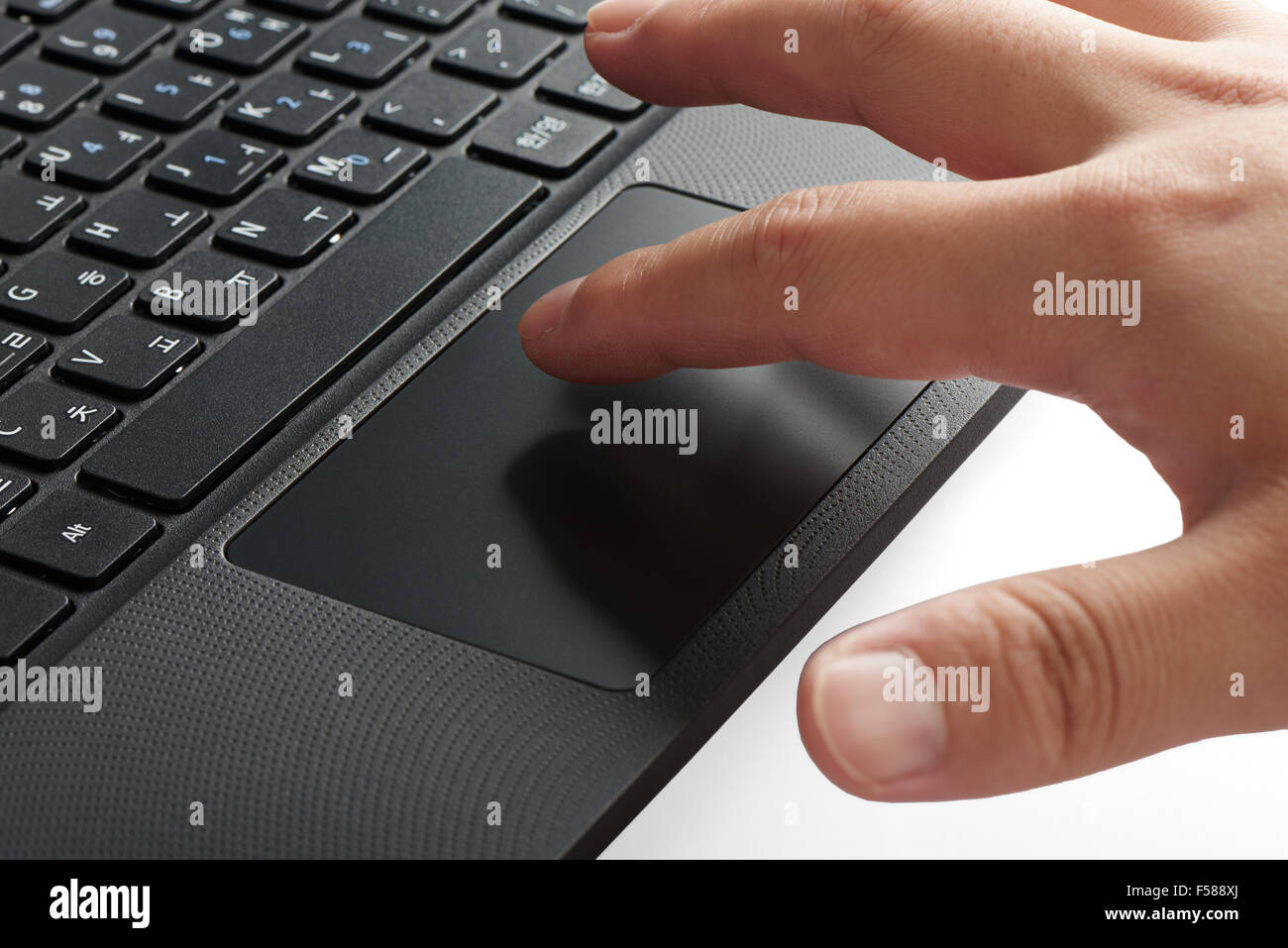 closeup of keypad and touchpad of a laptop computer with index fingers touching the touchpad Stock Photo