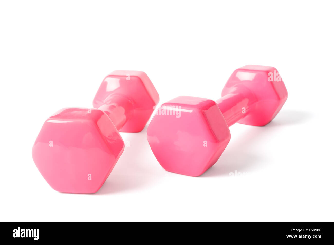 two dumbells covered with pink colored rubber, isolated on white. Stock Photo