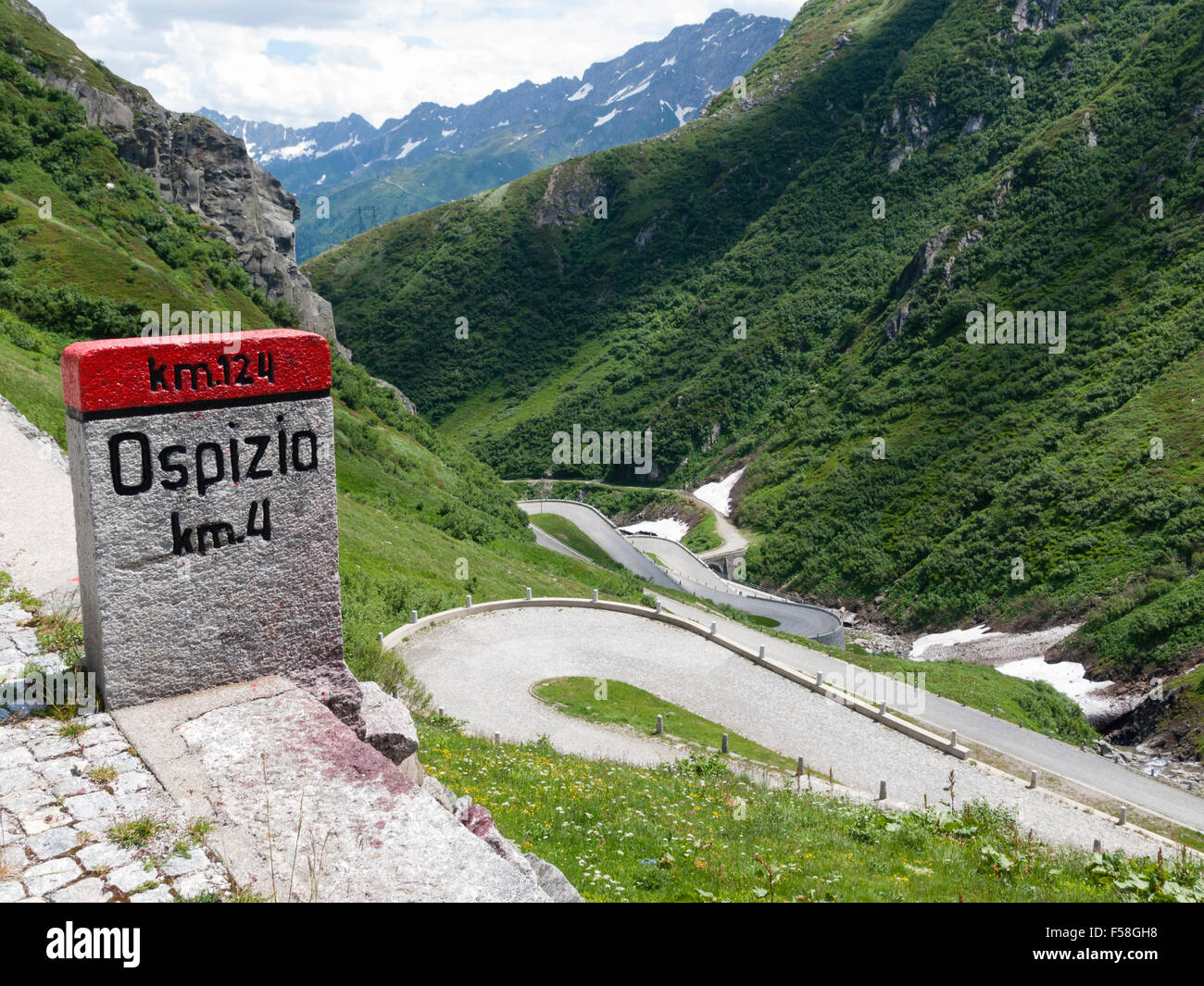 Milestone and serpentines of  the historic cobble stone paved Gotthard mountain pass road (Tremola) in the Swiss alps. Stock Photo