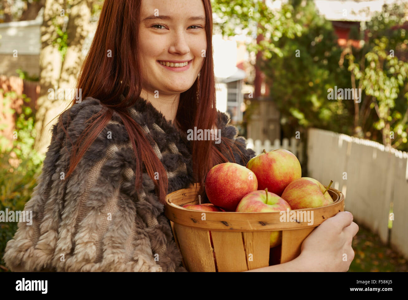 Young Woman With Basket of Apples Stock Photo