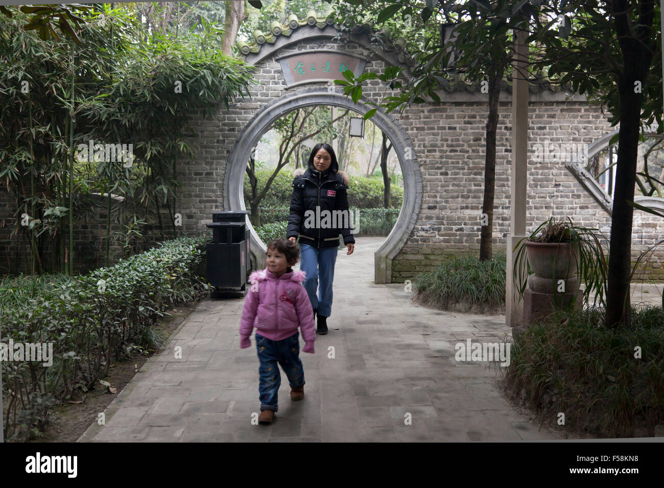 A mother follows her daughter in an old garden at an old town called Gucheng in Pixian at the outskirts of Chengdu in China. Stock Photo