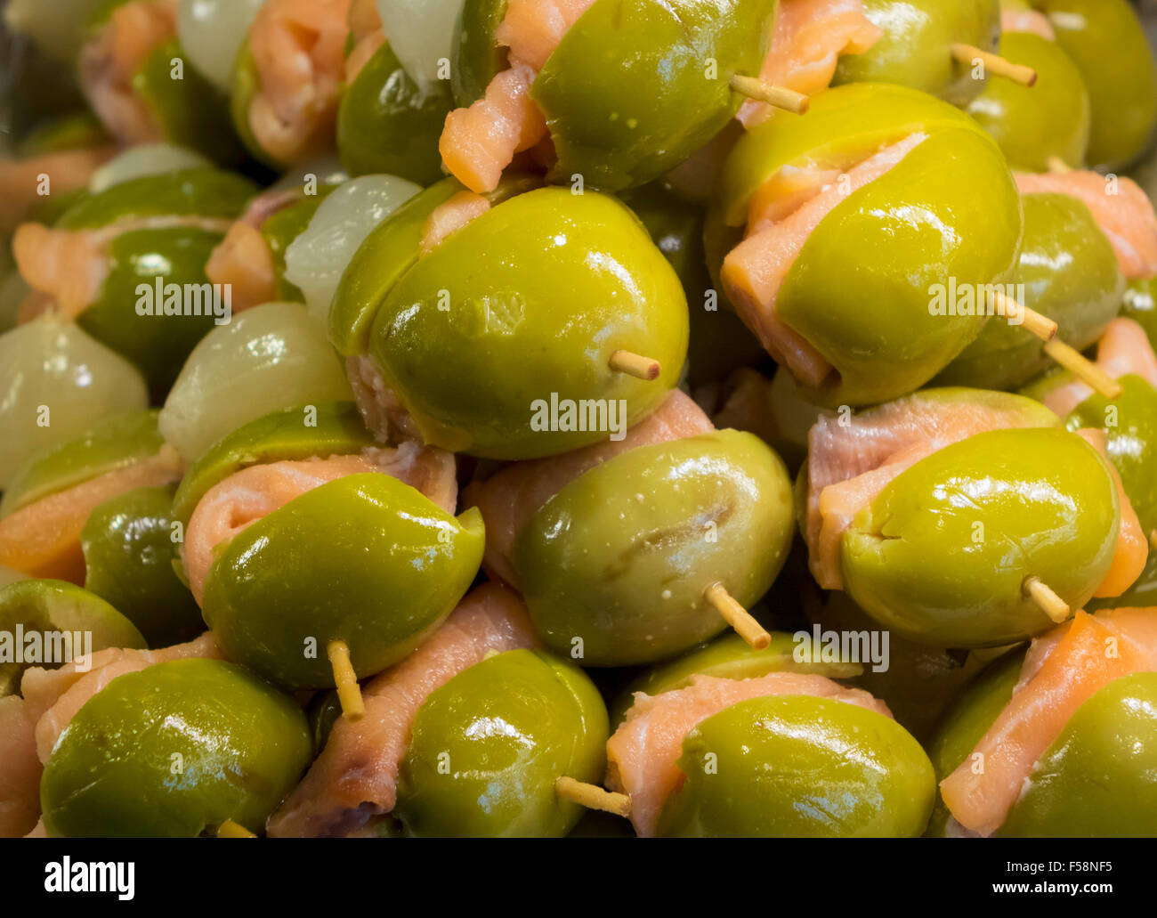 Green olives and salmon on plate of hors-d'oeuvres or entradas in food counter in Spanish market in Madrid Stock Photo