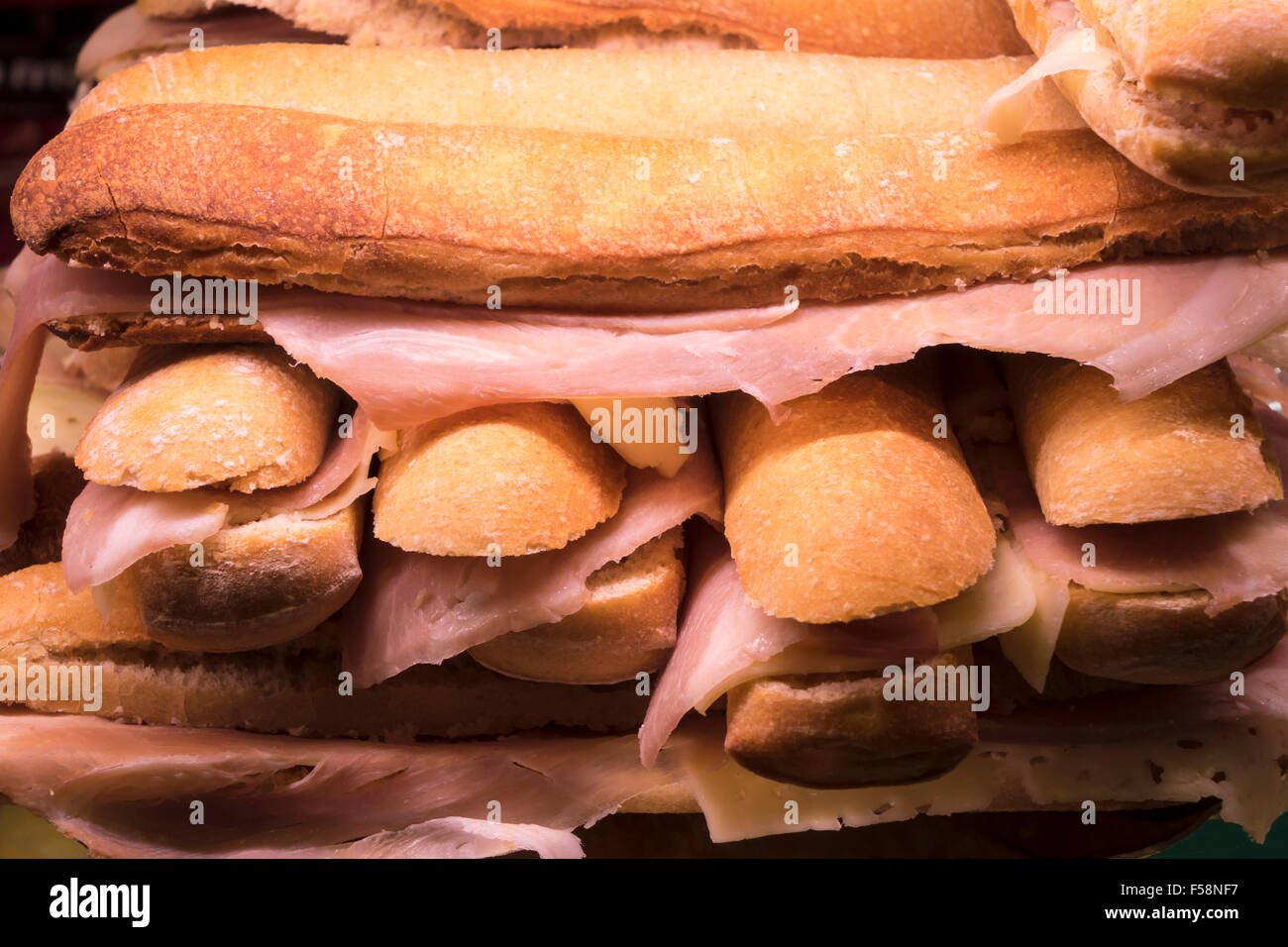 Stack of ham and cheese baguettes sandwiches on food counter in Spanish market in Madrid Stock Photo