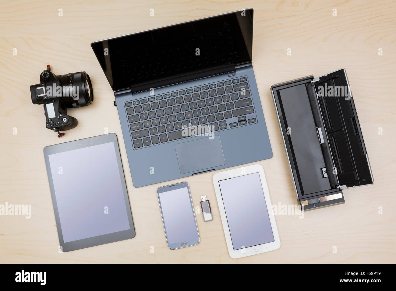 Overhead view of digital equipment, devices or gadgets - laptop, notebook, camera, tablet, phone, scanner on a desk Stock Photo