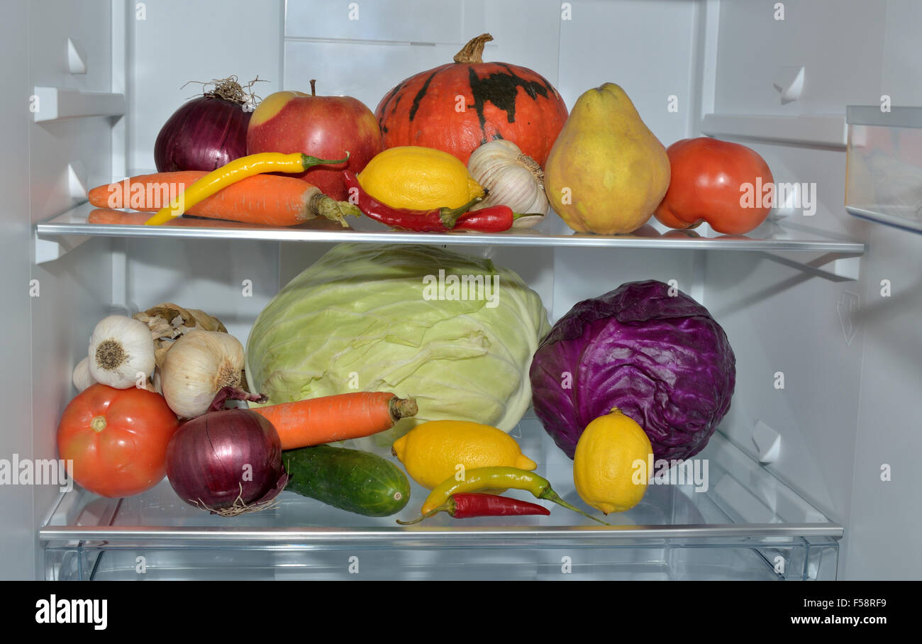 Two refrigerator shelves with fresh fruits and vegetables Stock Photo