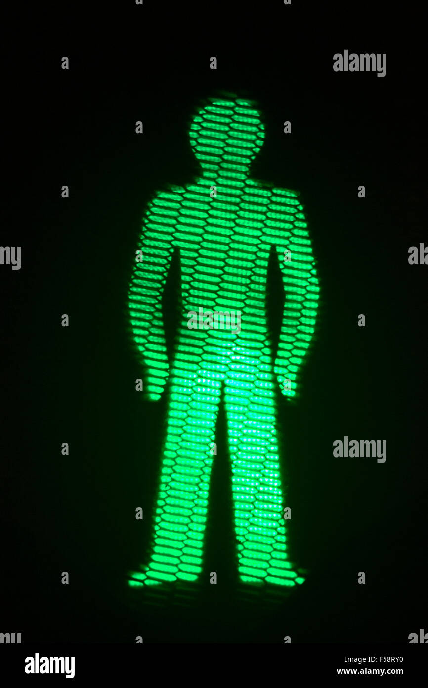 Green man go pedestrian traffic light photo at night on black