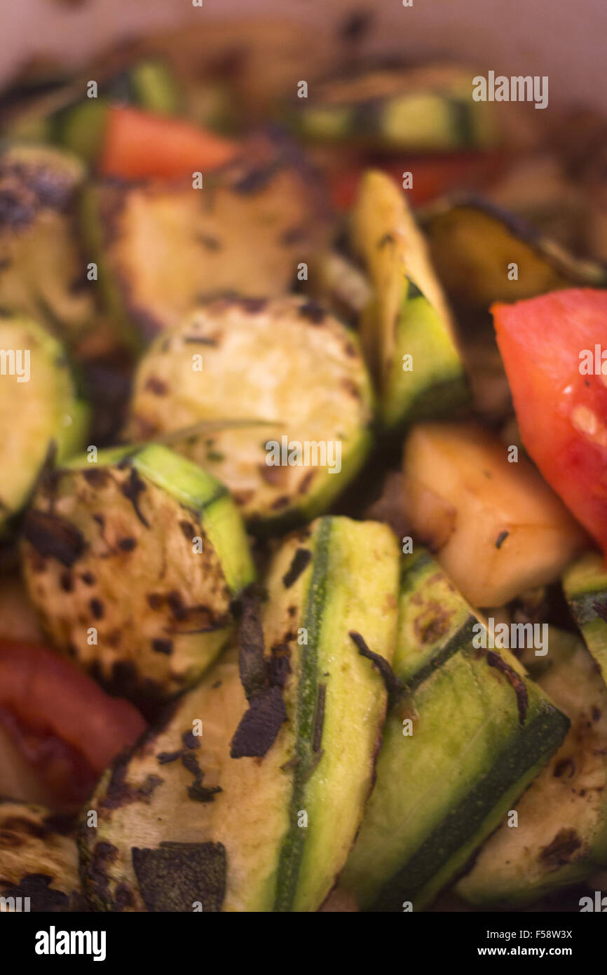 Frying zucchini fried courgettes vegetables and chopped rosemary herbs