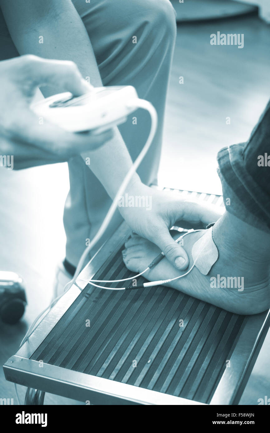 Patient foot, leg and ankle in electro physiotherapy electrical impulse