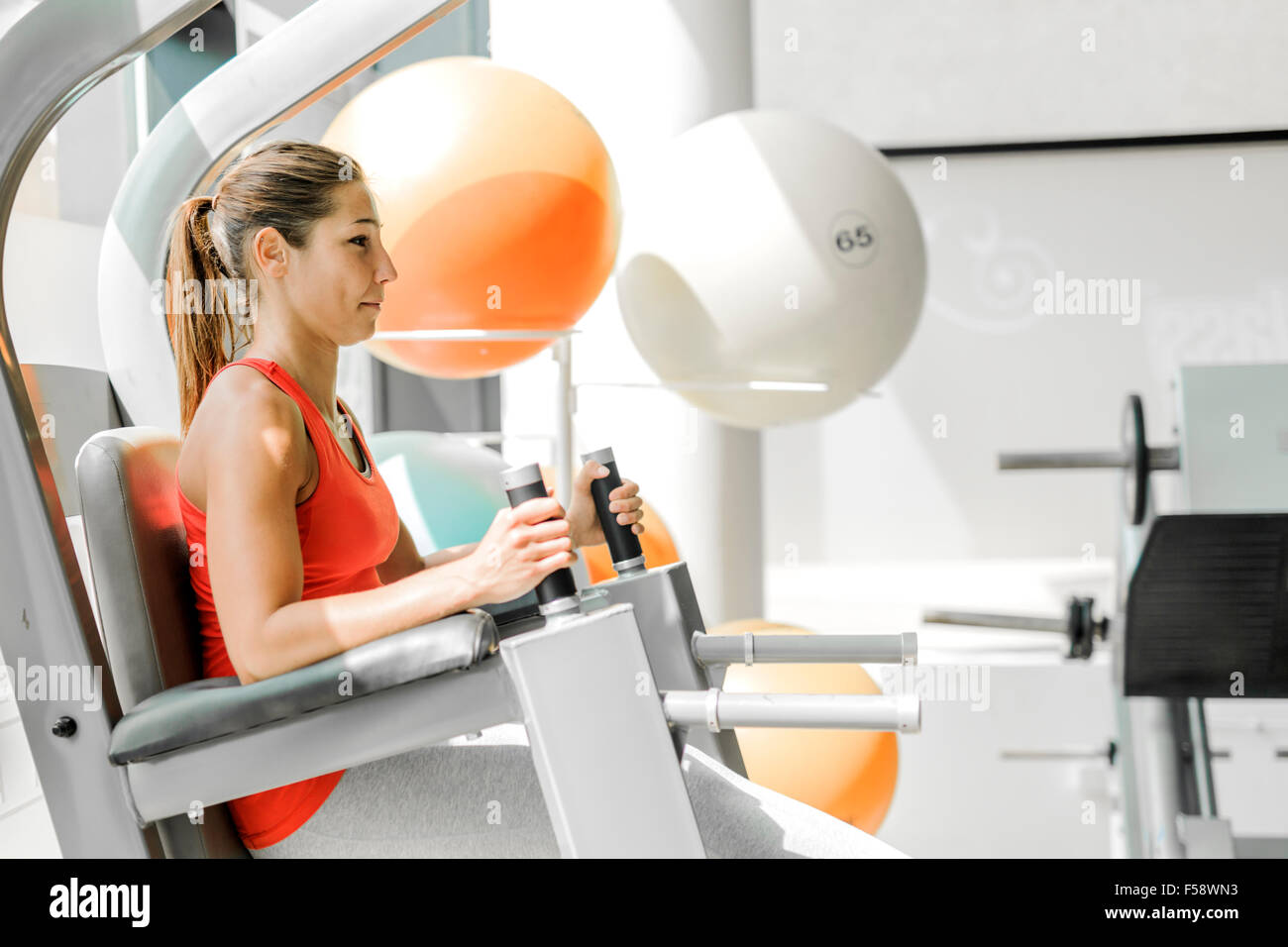 Young woman working on abs muscle in a gym Stock Photo