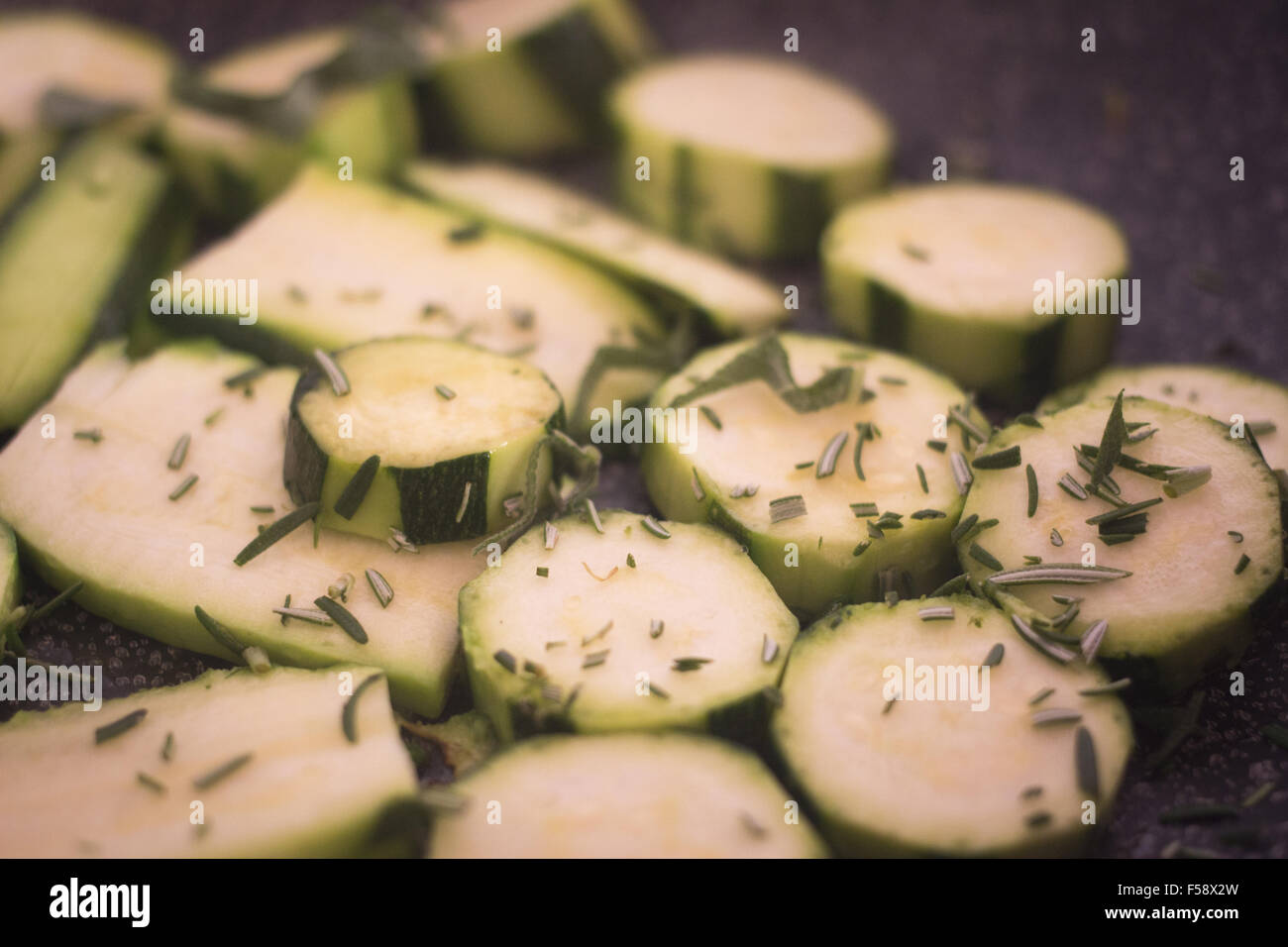 Frying zucchini fried courgettes vegetables and chopped rosemary herbs