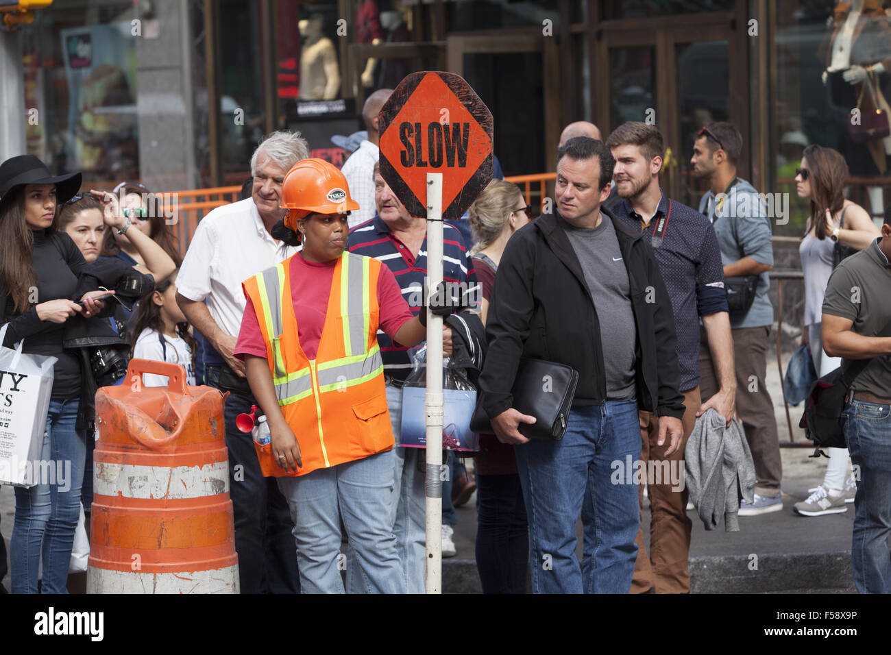 Female construction worker on the job directing people & traffic to