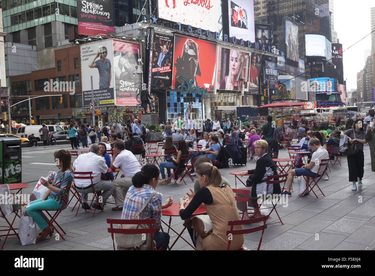 People relax in Times Square between Broadway & 7th Avenue in NYC. Stock Photo