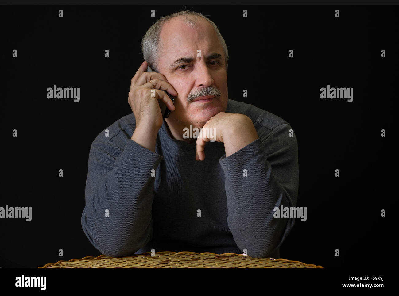 Portrait of mature Caucasian man listening cellular phone Stock Photo