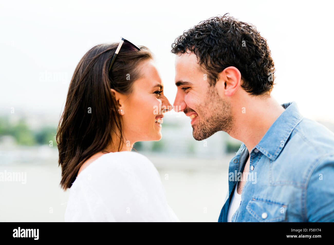 Young beautiful couple rubbing noses as a sign of love and about to kiss each other Stock Photo