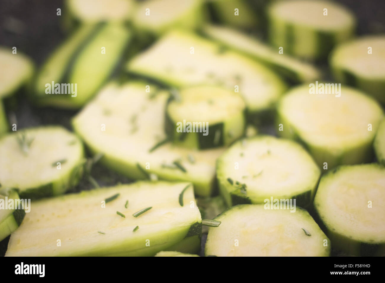 Frying zucchini fried courgettes vegetables and chopped rosemary herbs