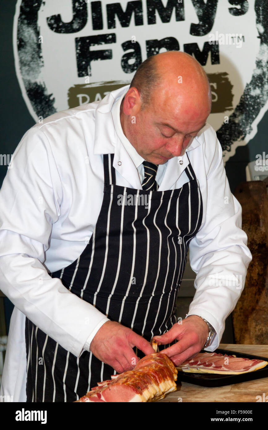 Butcher preparing bacon in The Butchery, Jimmy's Farm, Wherstead, Ipswich, UK Stock Photo