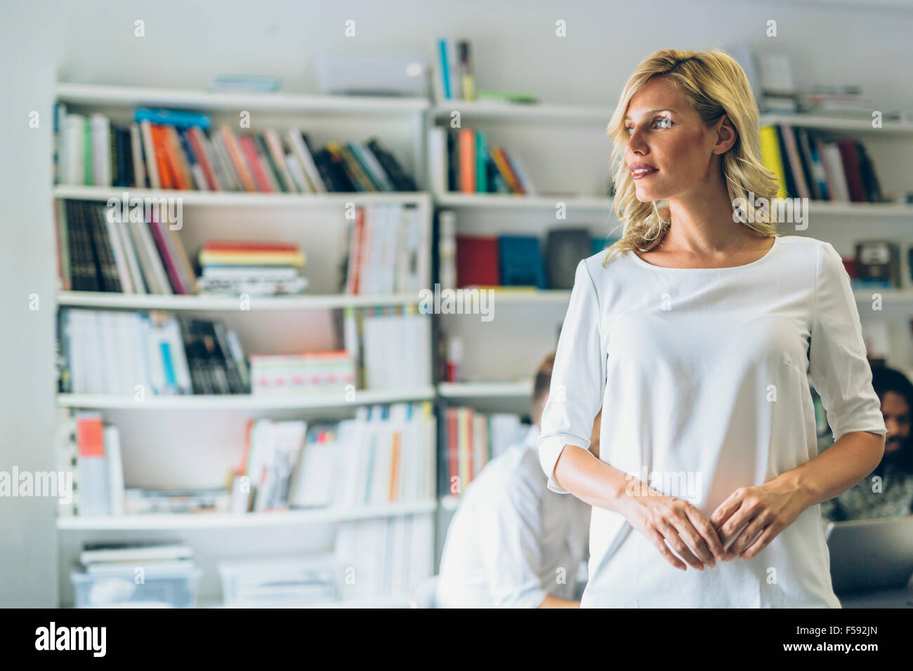 Portrait of a beautiful blonde woman in library Stock Photo