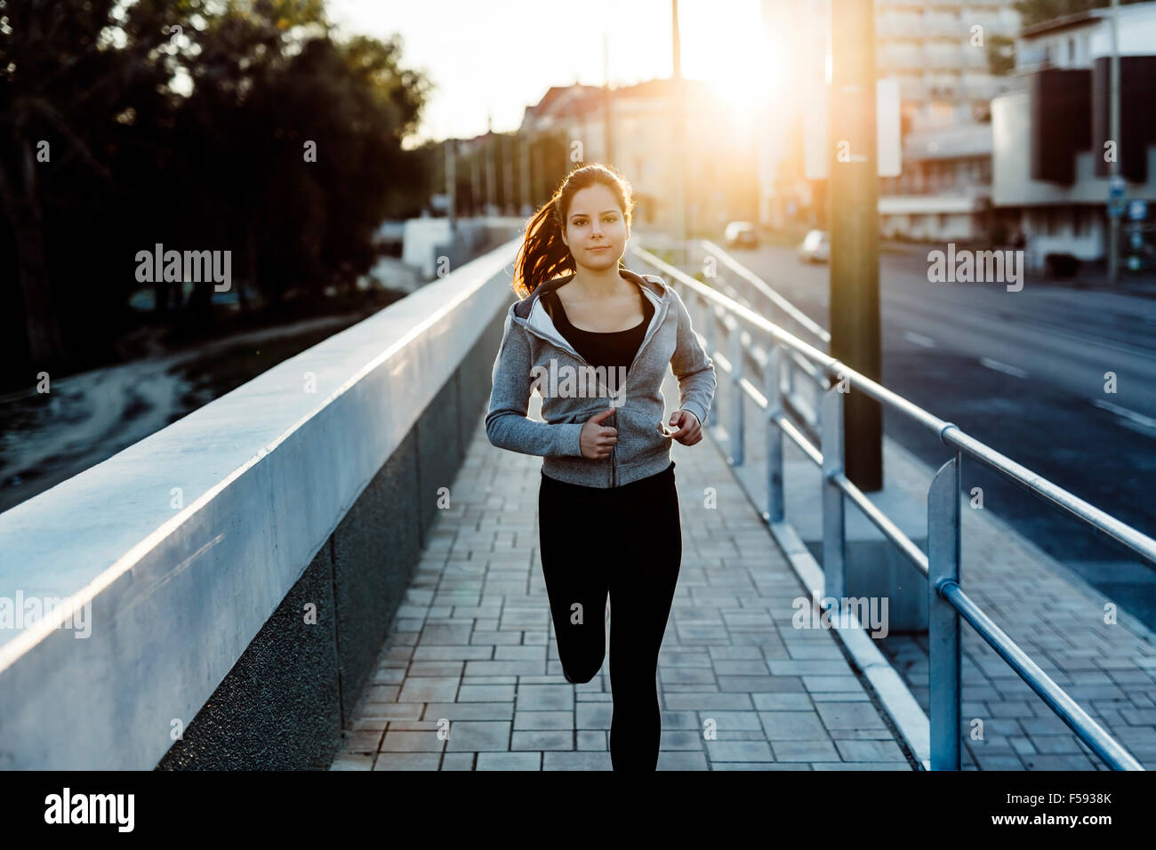 Beautiful female jogging in city and keeping her body in shape Stock Photo