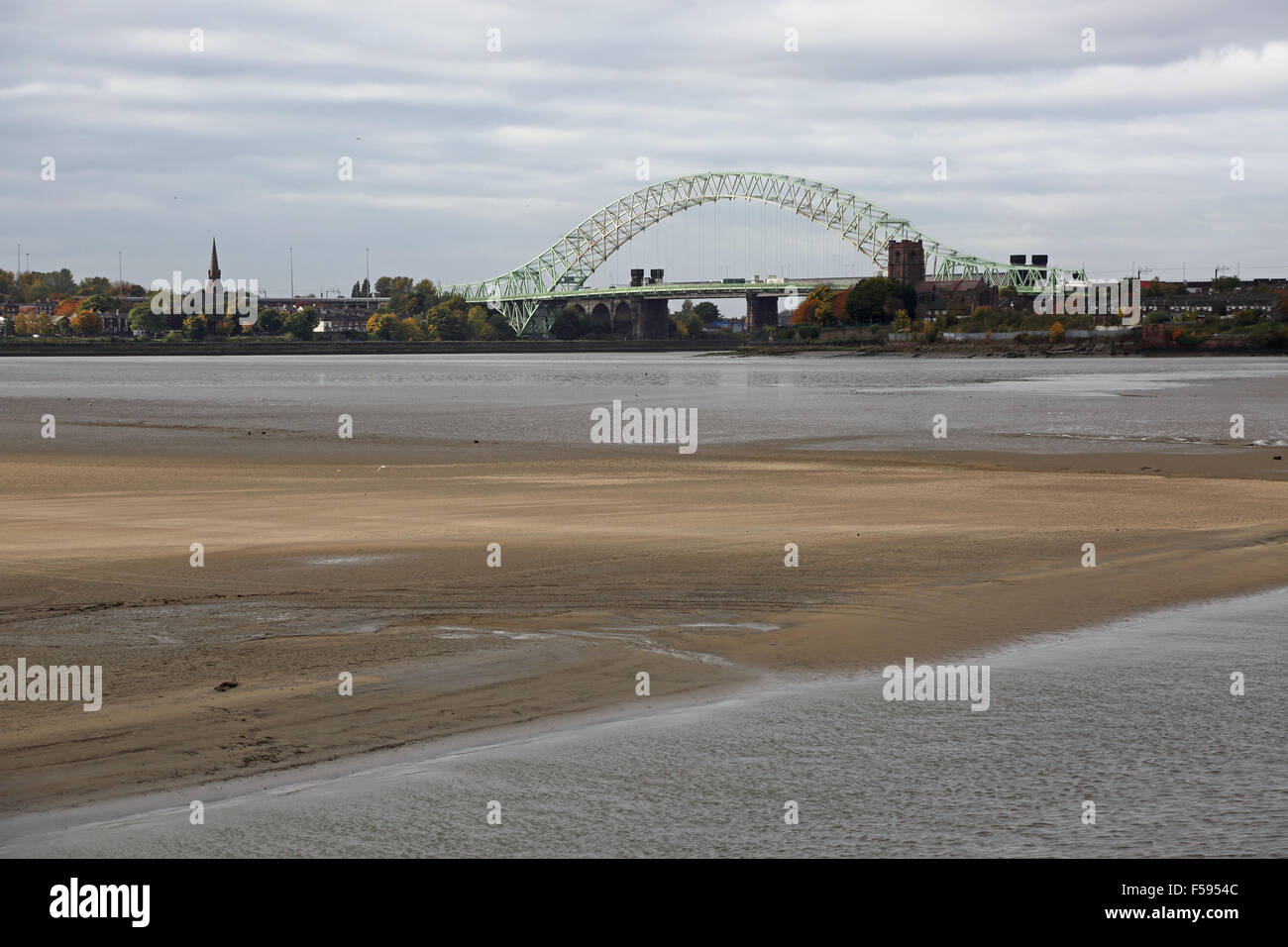 The Silver Jubilee Bridge across the River Mersey at Runcorn viewed from the east showing mudflats of the Mersey estuary Stock Photo