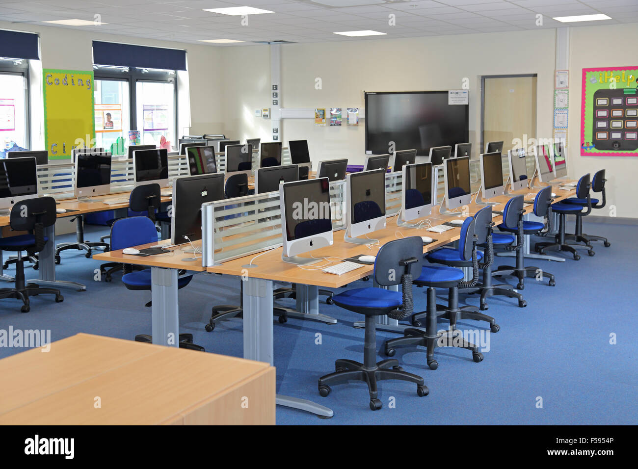 A computer and IT studies classroom in a newly built UK junior school. Shows 32 desks with new Apple Mac desktop computers Stock Photo