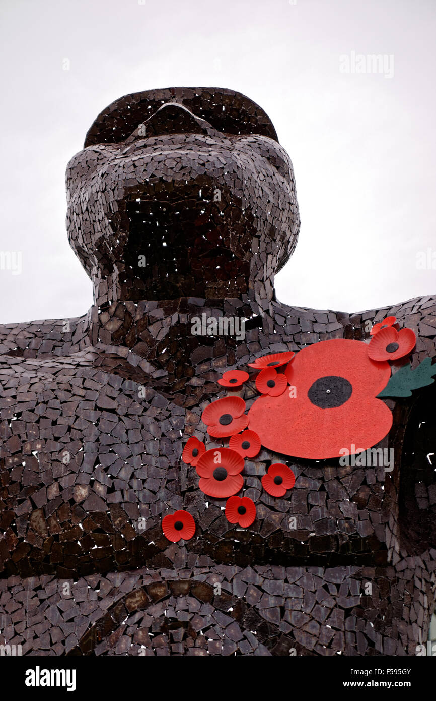 remembrance poppies on iron sculpture of man Stock Photo
