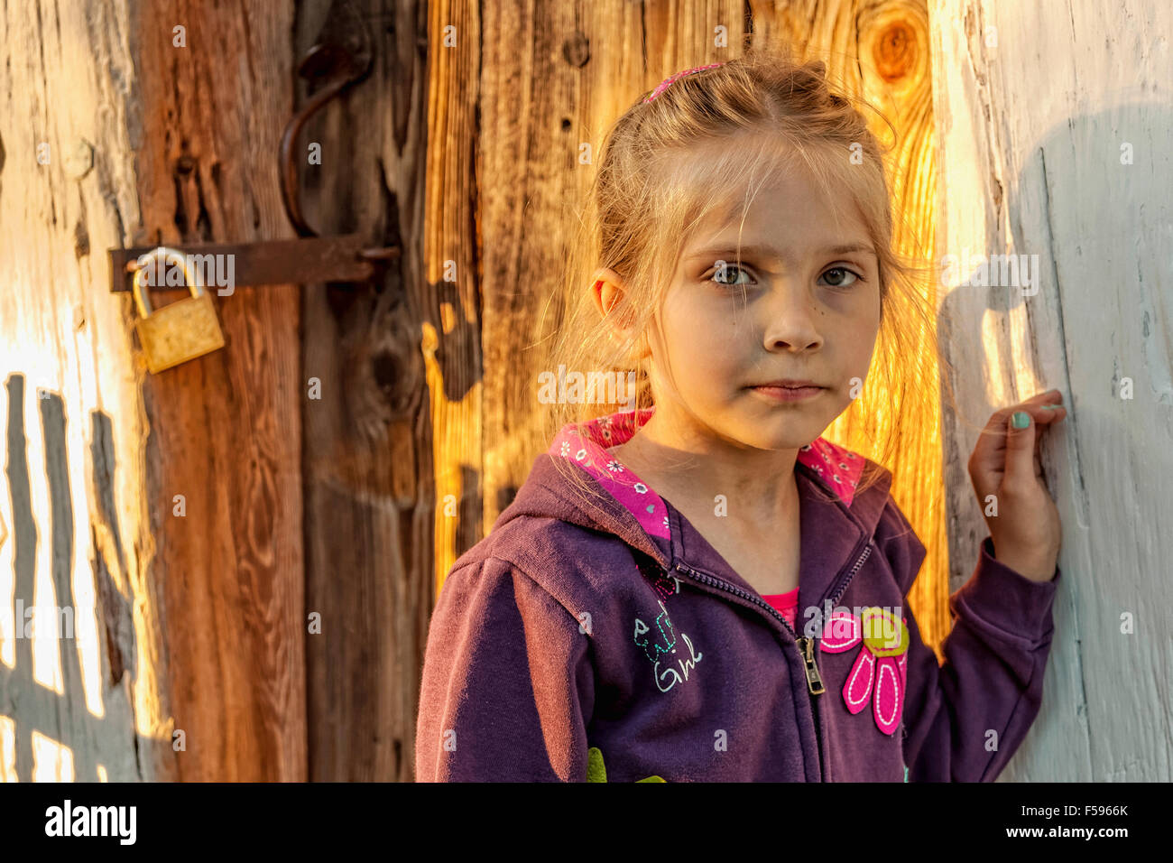 Girl standing next to wooden door of an old house in Tokarnia open-air ...