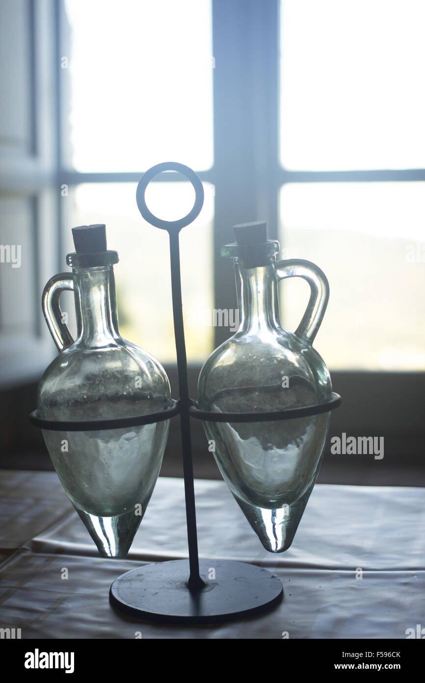 Vintage manual retro oil vinegar jars on table in old country house