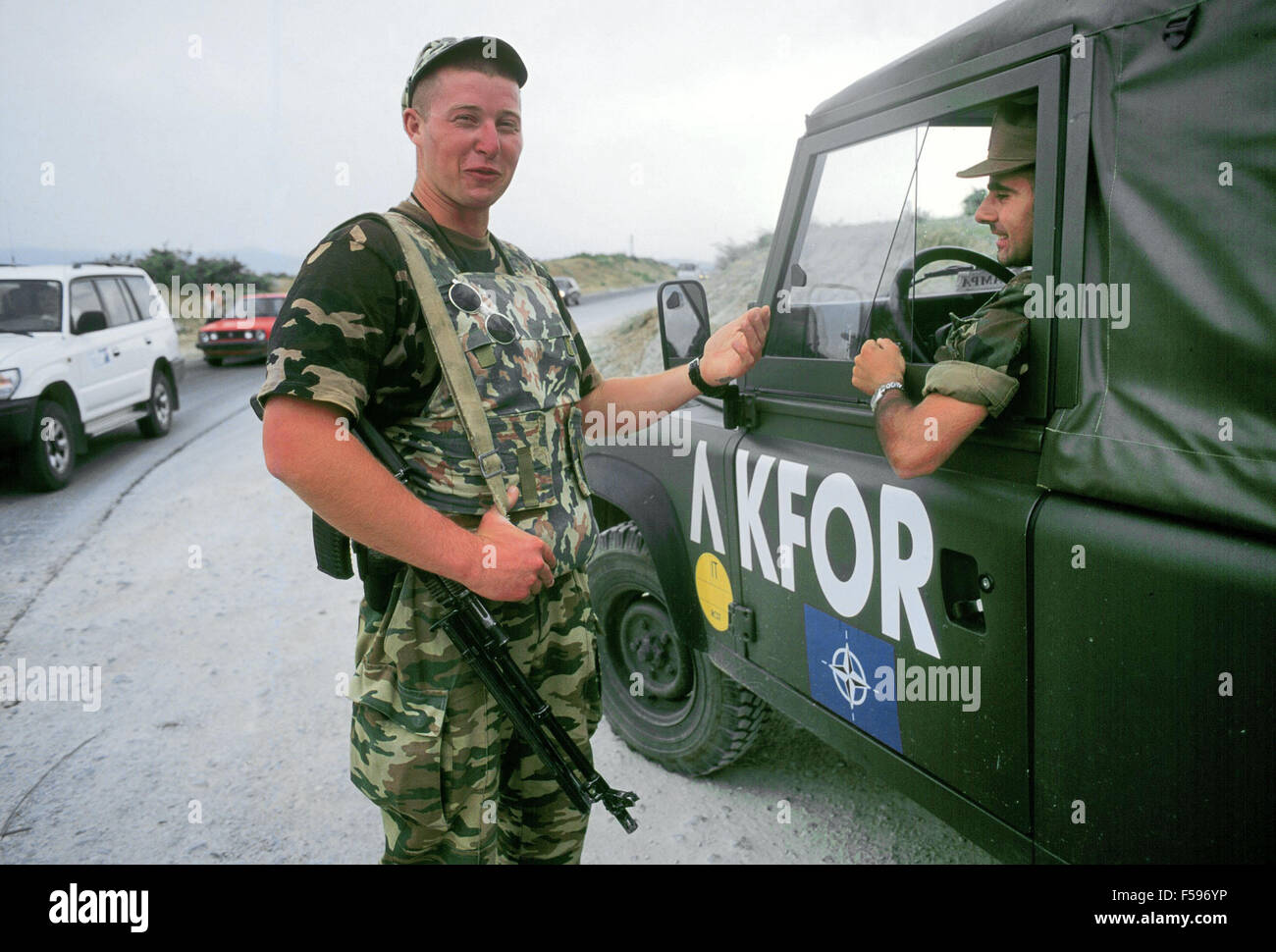 NATO intervention in Kosovo, July 2000 Russian soldier on watch to a checkpoint on the Pristina-Pec road speaks with the driver of an Italian Army vehicle Stock Photo