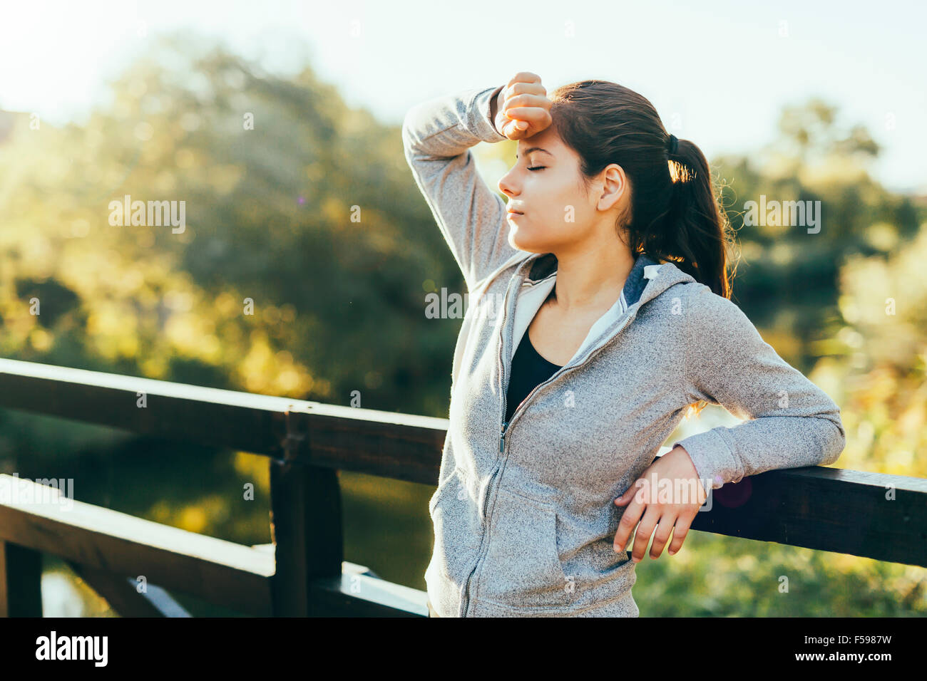 Beautiful woman resting after jogging outdoors and being exhausted Stock Photo
