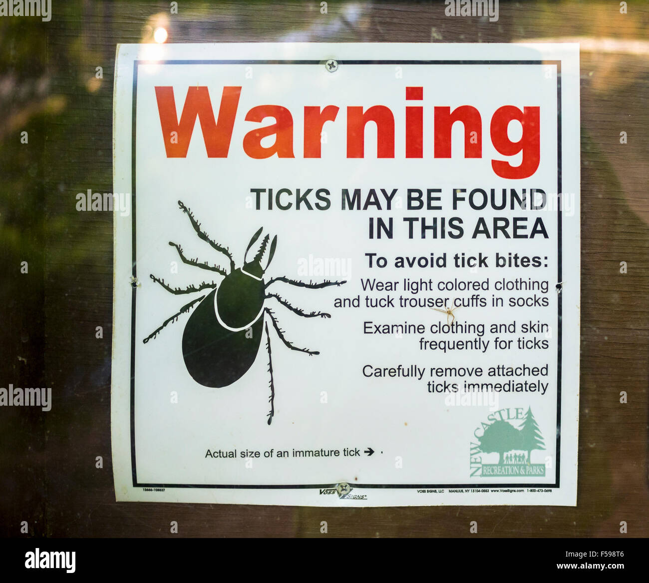 Deer tick warning poster sign notice posted on a hiking trail path Westchester County New York Lyme Disease public health issue Stock Photo