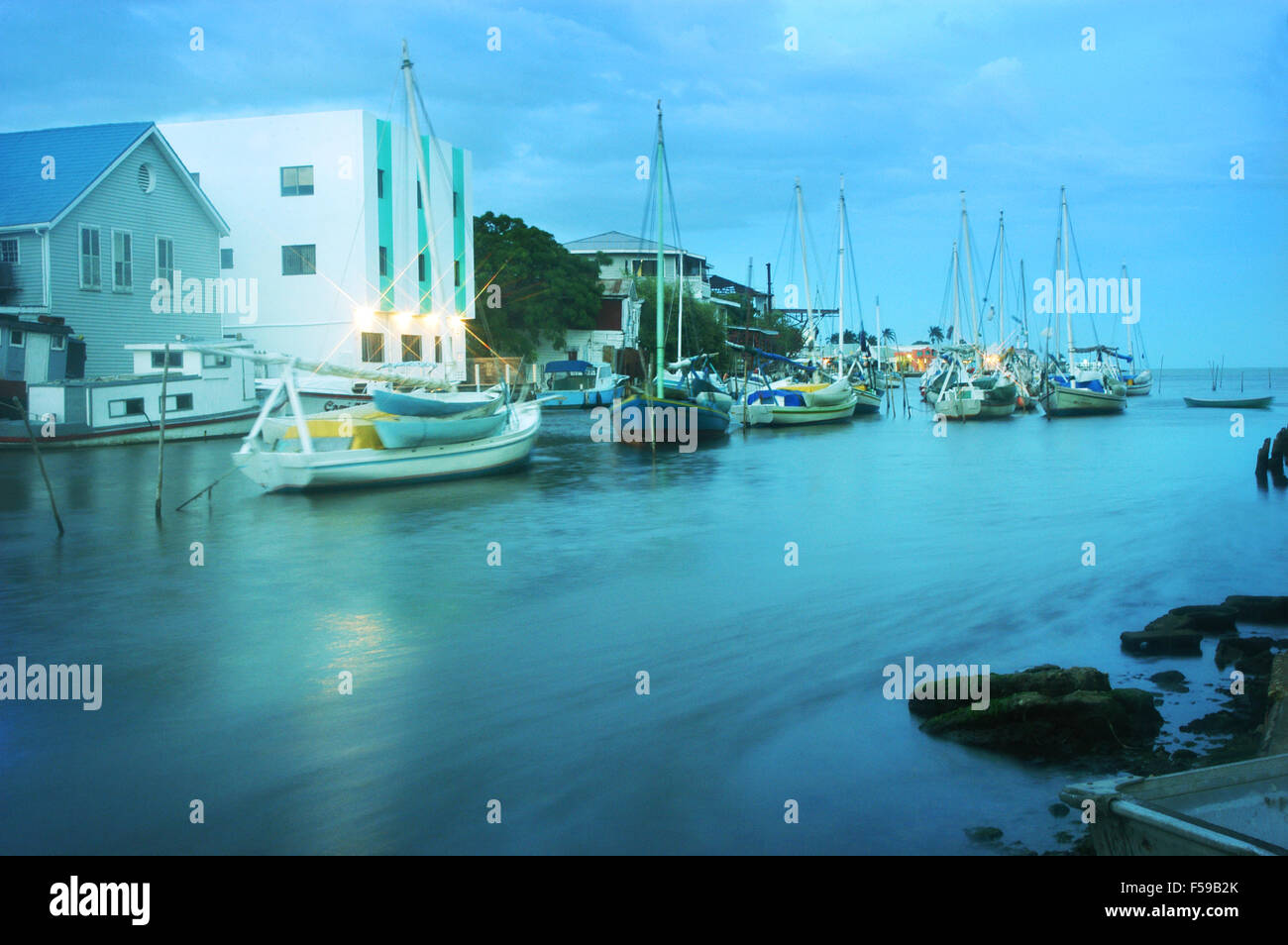 View from the historic Swing Bridge in Belize City at dusk. The sandlighters rock gently in the wake of Haul Over Creek. Stock Photo